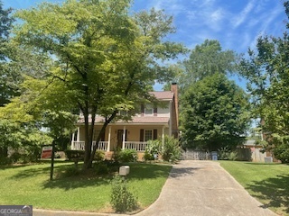 a front view of a house with a yard and trees