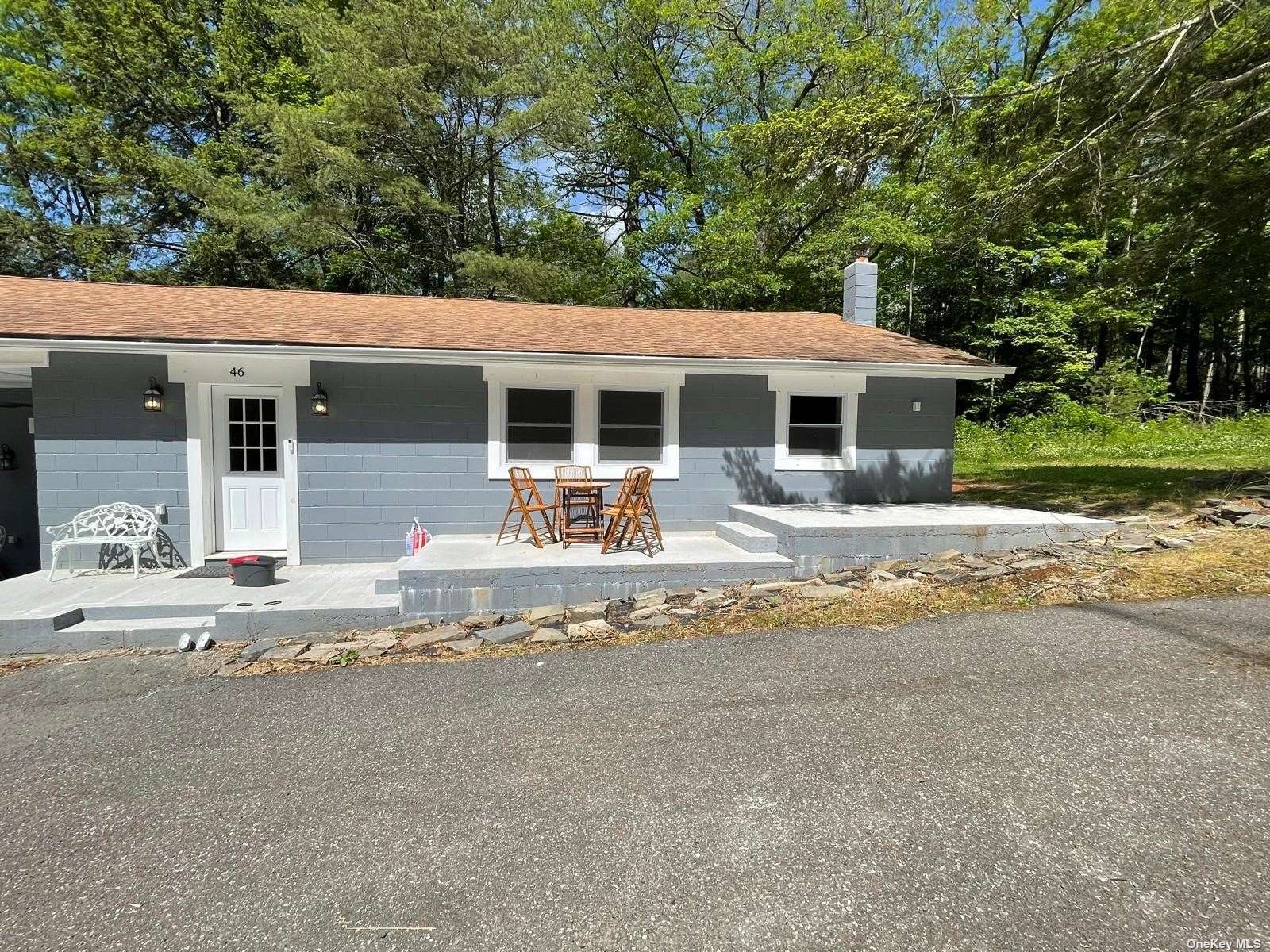 a front view of house with yard and trees around