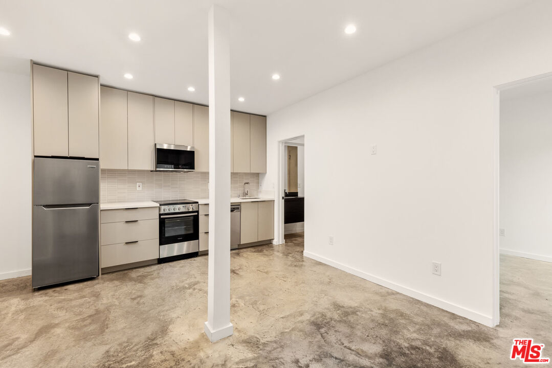 a kitchen with stainless steel appliances a refrigerator sink and stove