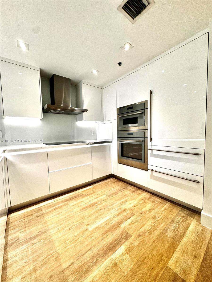 a kitchen with stainless steel appliances kitchen island granite countertop a refrigerator and a sink