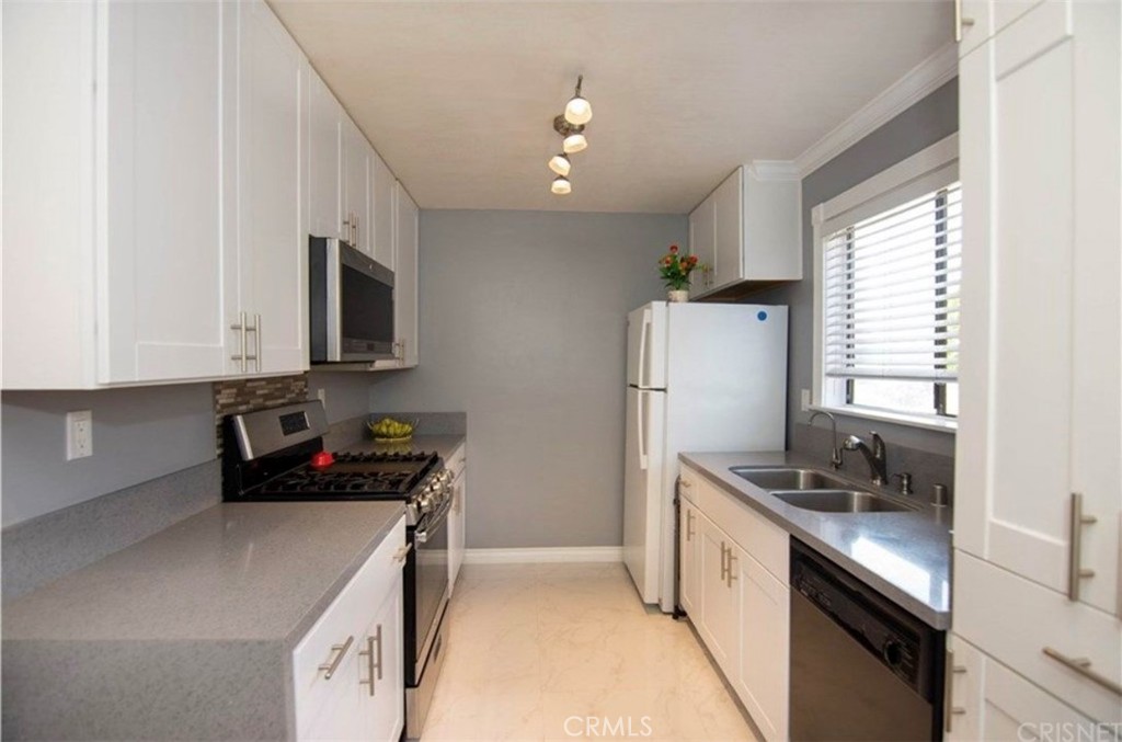 a kitchen with stainless steel appliances a sink stove and microwave