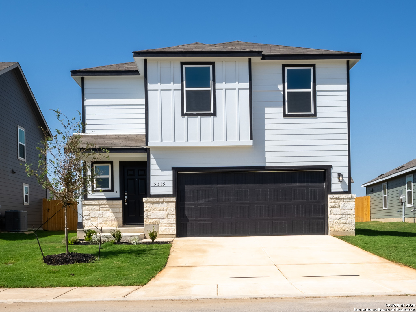 a front view of a house with a yard and garage