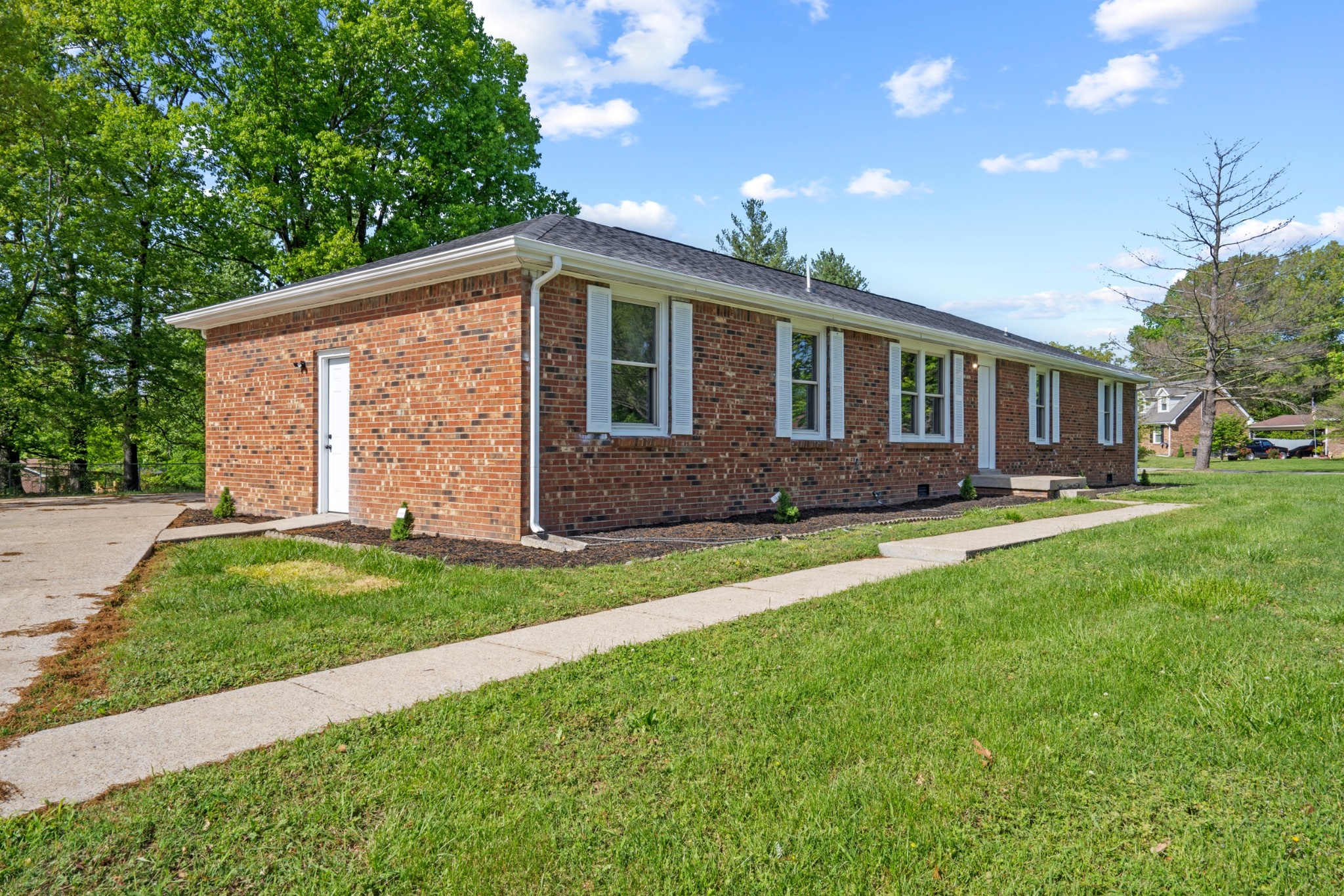 a front view of a house with a yard and green space