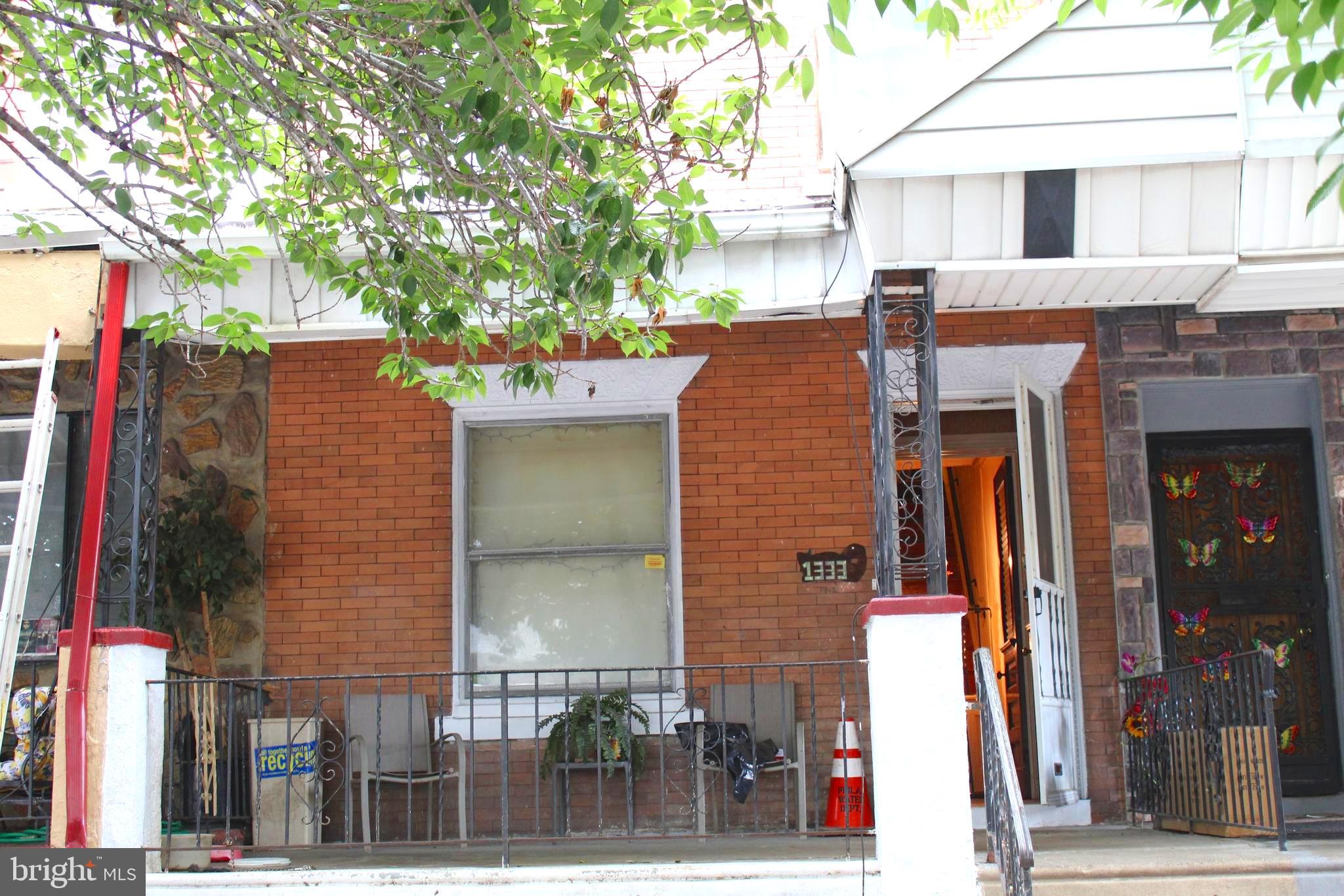 a front view of a building with a tree