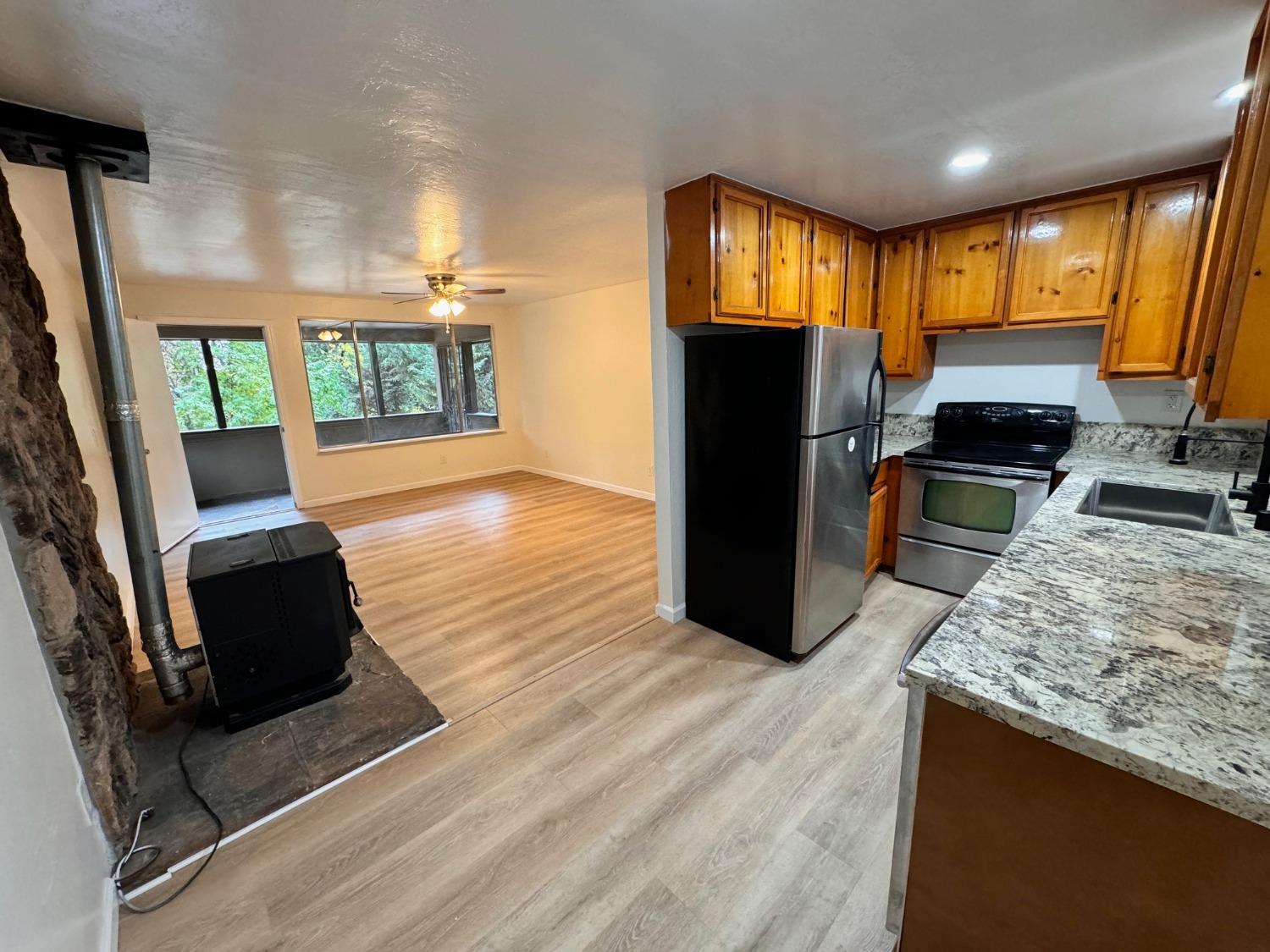 a kitchen with stainless steel appliances granite countertop a refrigerator stove top oven dining table and chairs