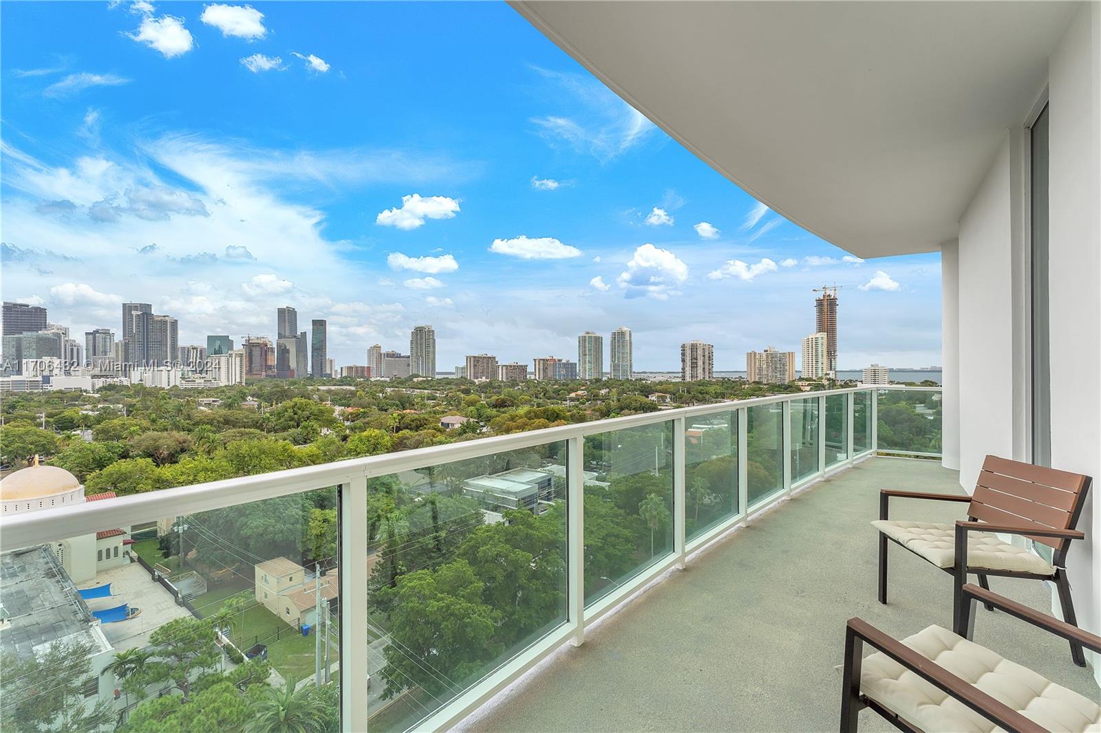 a view of a city from a balcony with furniture