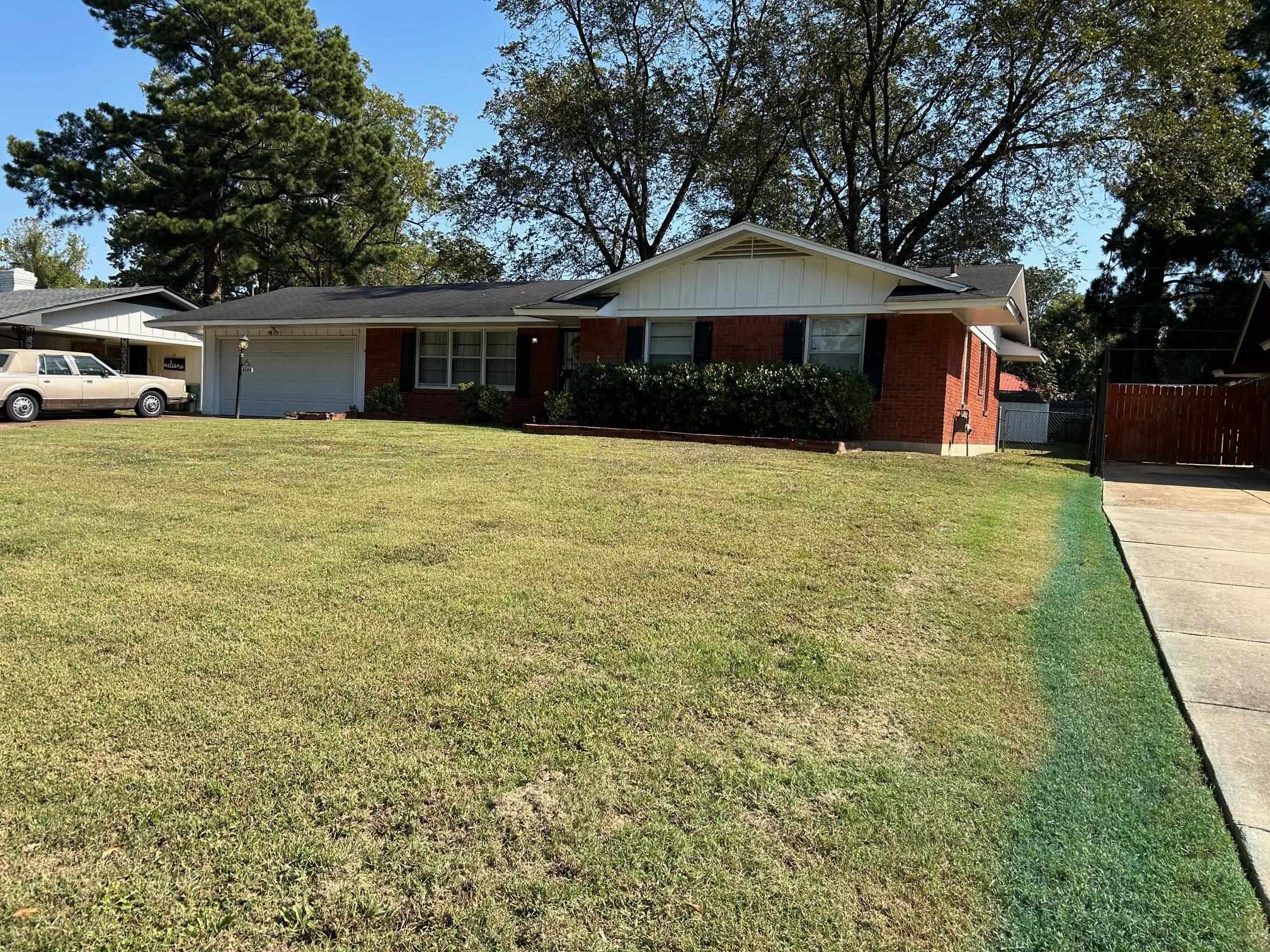 Ranch-style home featuring a garage and a front lawn