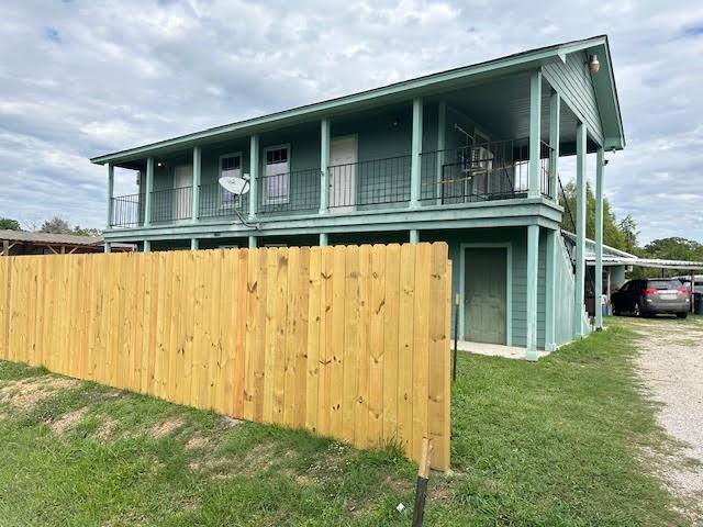 a view of a house with a window and wooden fence