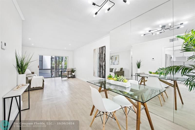 a living room with furniture a chandelier and a dining table