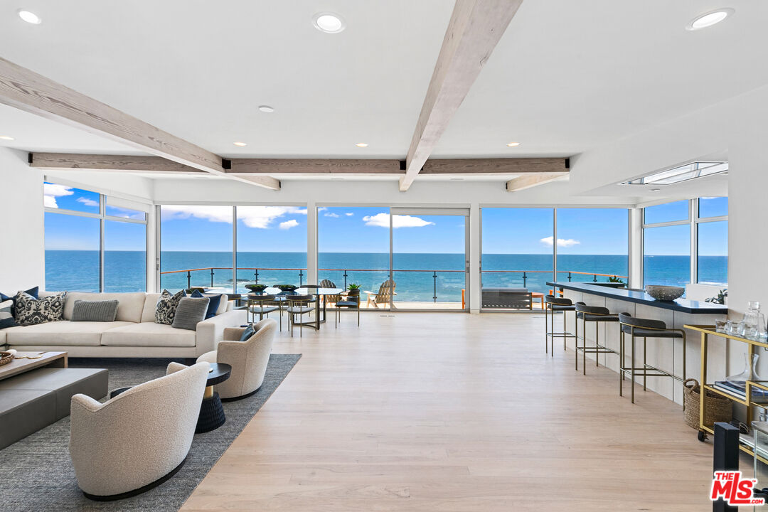 a living room with lots of furniture and view of kitchen