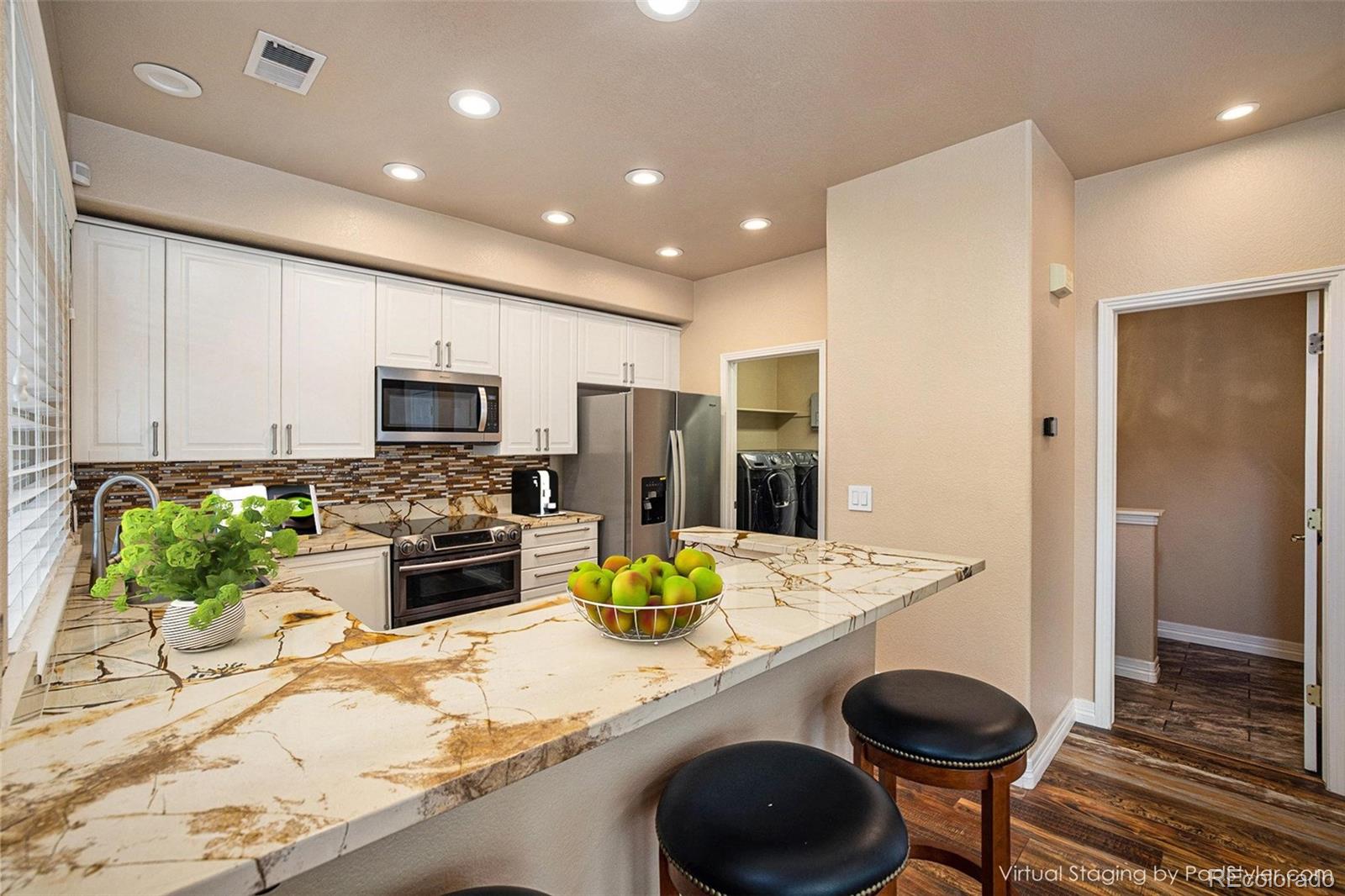 a kitchen with kitchen island granite countertop a sink appliances and cabinets