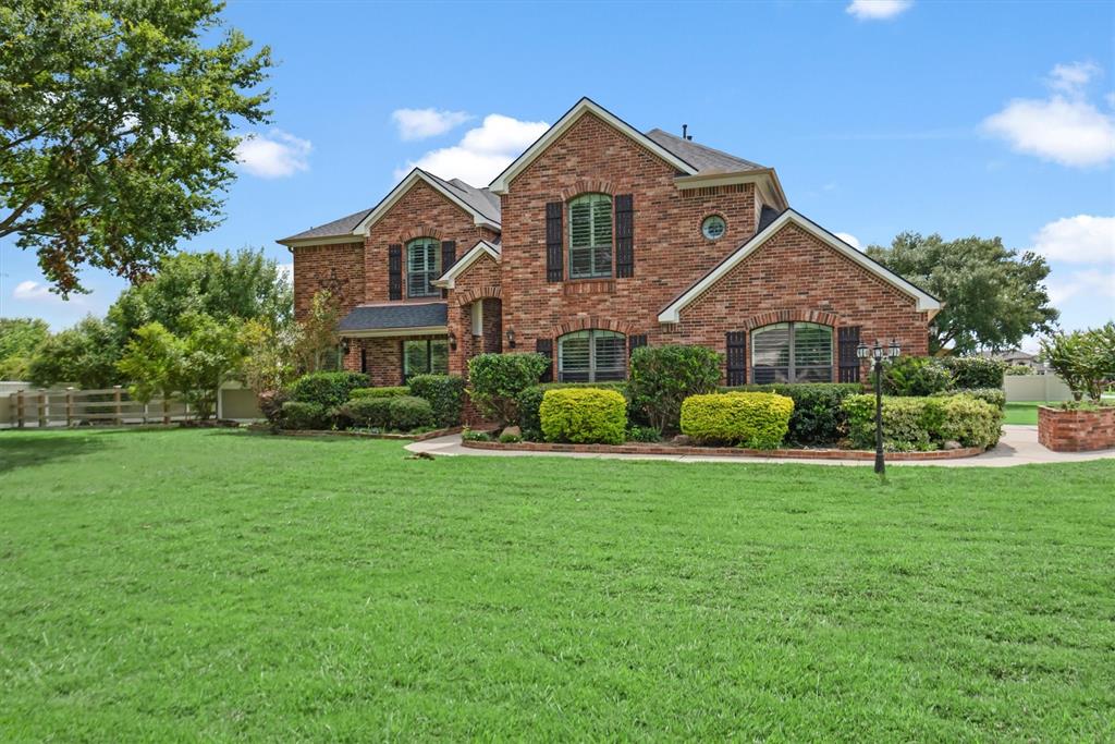 a front view of a house with a yard and trees