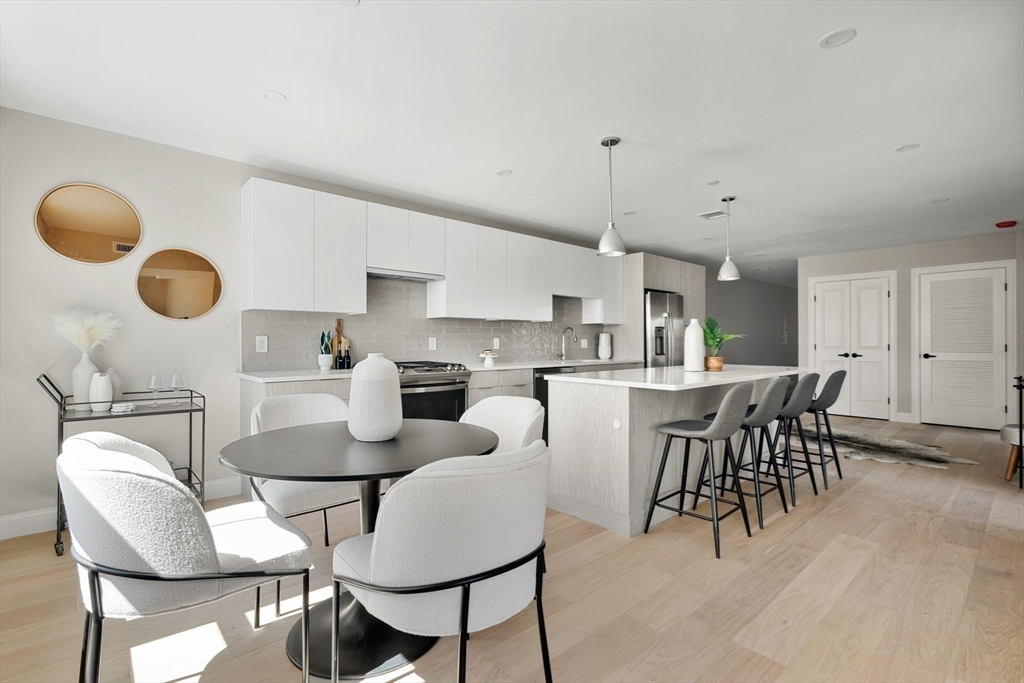 a kitchen with a dining table chairs and white cabinets