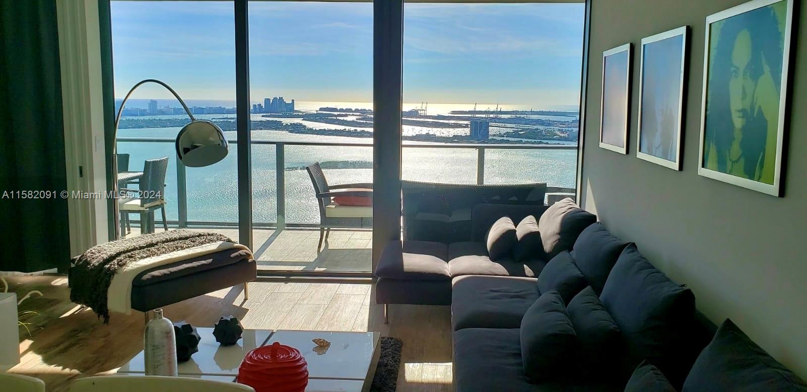 a living room with furniture and a floor to ceiling window