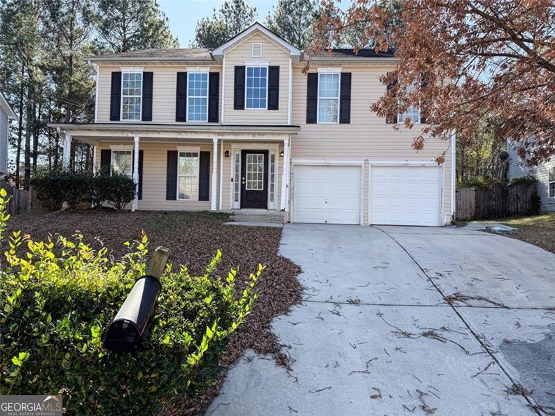 a front view of a house with a yard and a garden