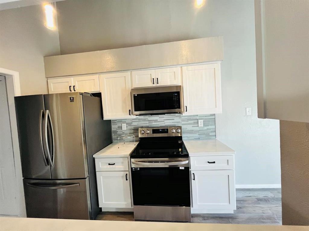 a kitchen with stainless steel appliances a refrigerator stove and microwave