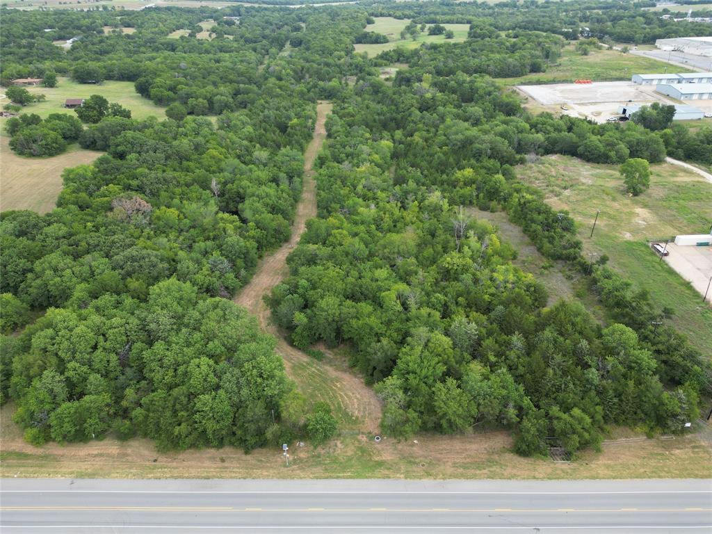 an aerial view of residential houses with outdoor space and trees