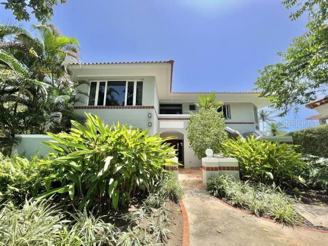 a front view of a house with lots of potted plants