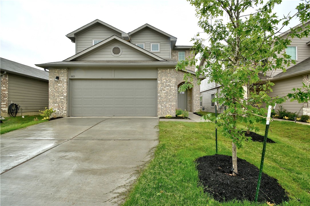 a front view of a house with a yard and garage