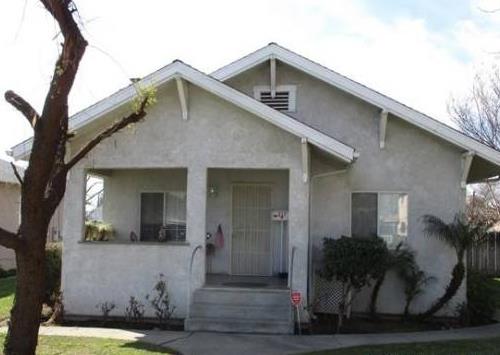 a front view of a house with plants