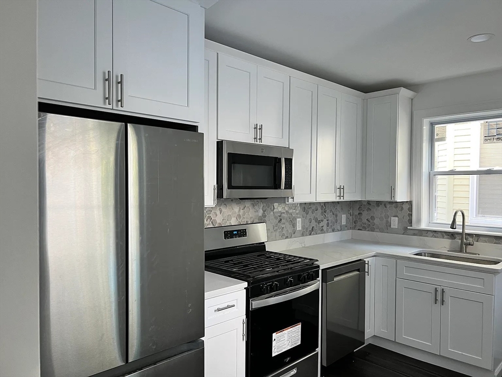 a kitchen with stainless steel appliances granite countertop a stove a refrigerator and a sink