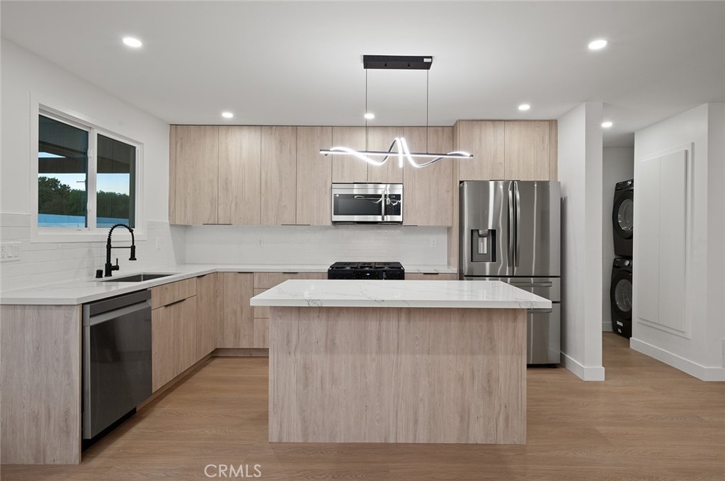 a kitchen with stainless steel appliances granite countertop a sink stove and refrigerator