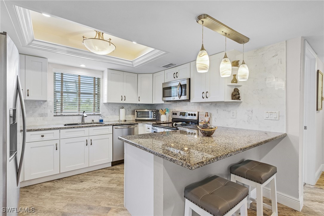 a kitchen with granite countertop cabinets stainless steel appliances a sink and a island