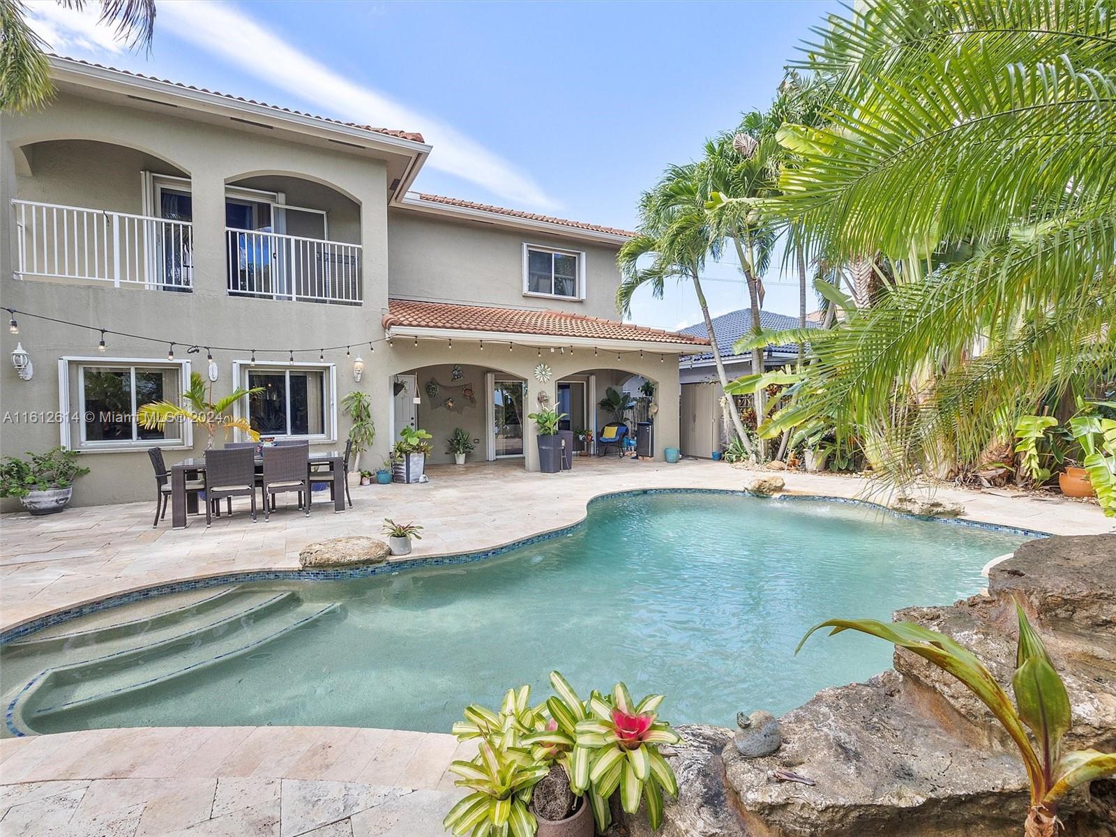 a view of a house with swimming pool and sitting area