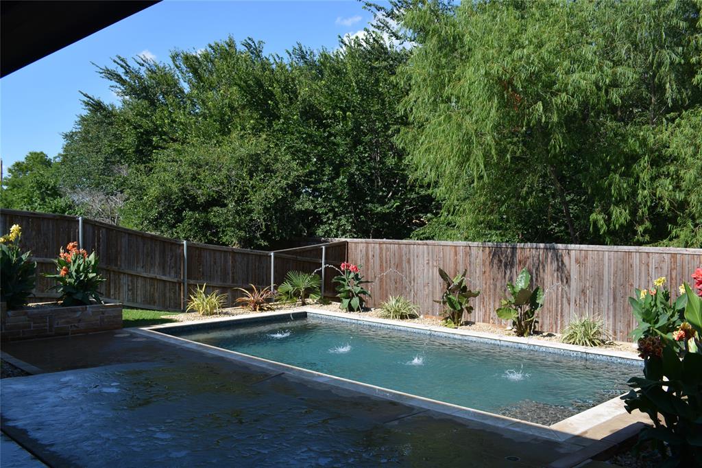 a view of a small yard and a wooden deck