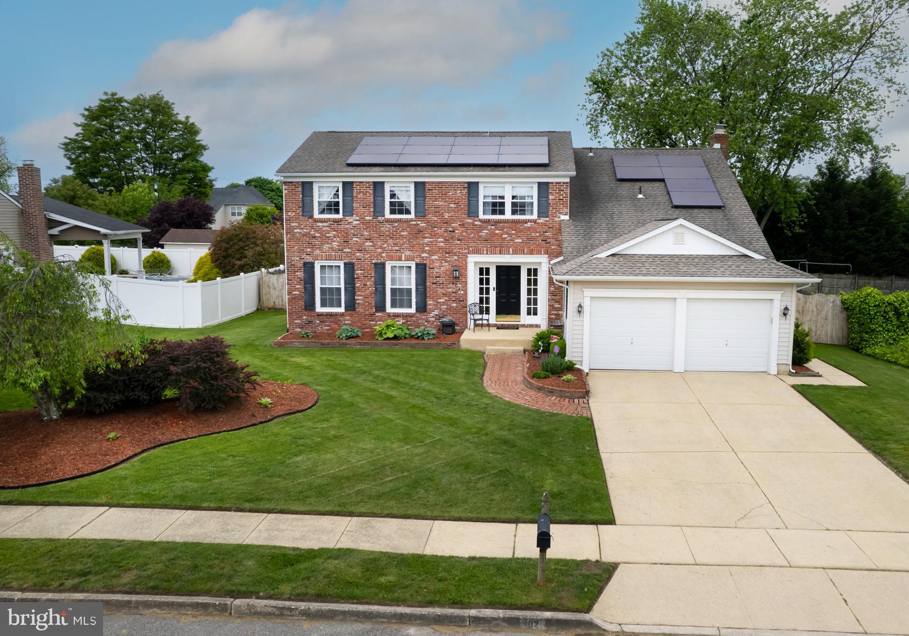 a front view of a house with a yard and trees