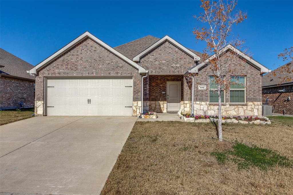 View of front of house featuring cooling unit, a front yard, and a garage