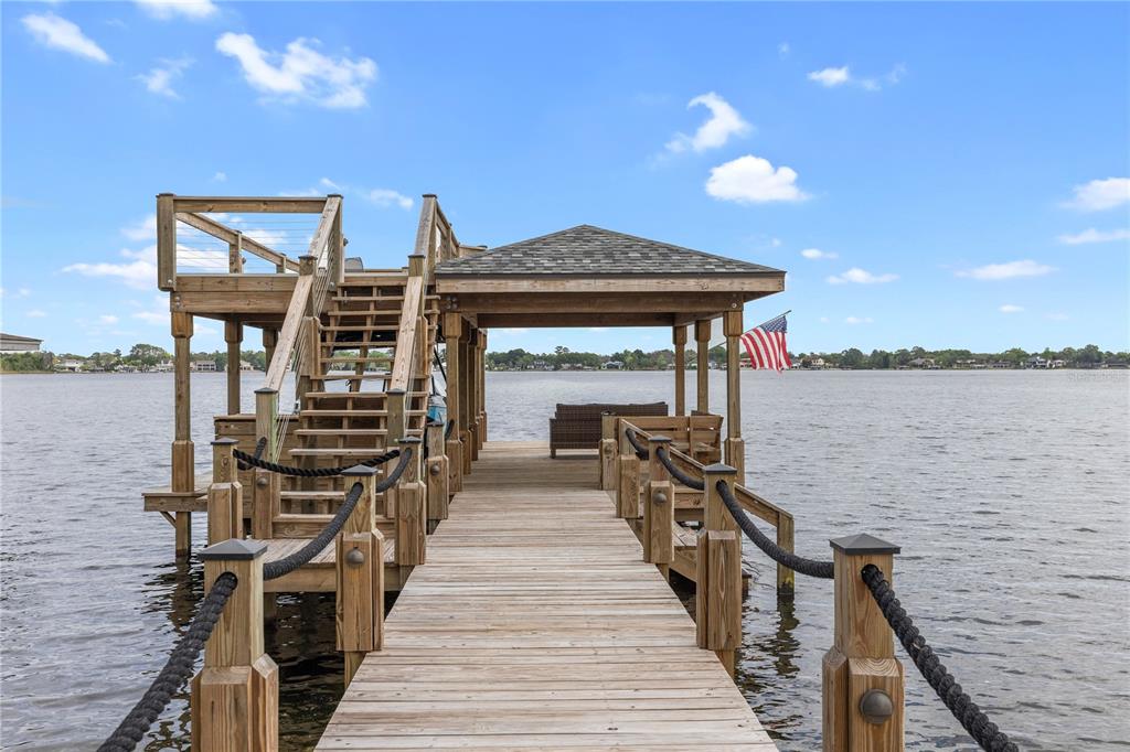 a view of a balcony with wooden floor and lake view