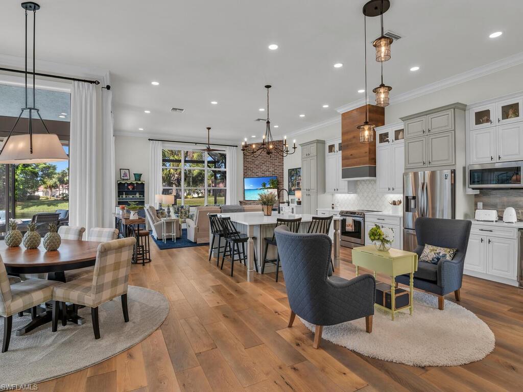 Open living space with light hardwood floors, custom window treatments, motorized blinds, custom kitchen, living area with fireplace, oversized windows with views everywhere.  Light and bright!