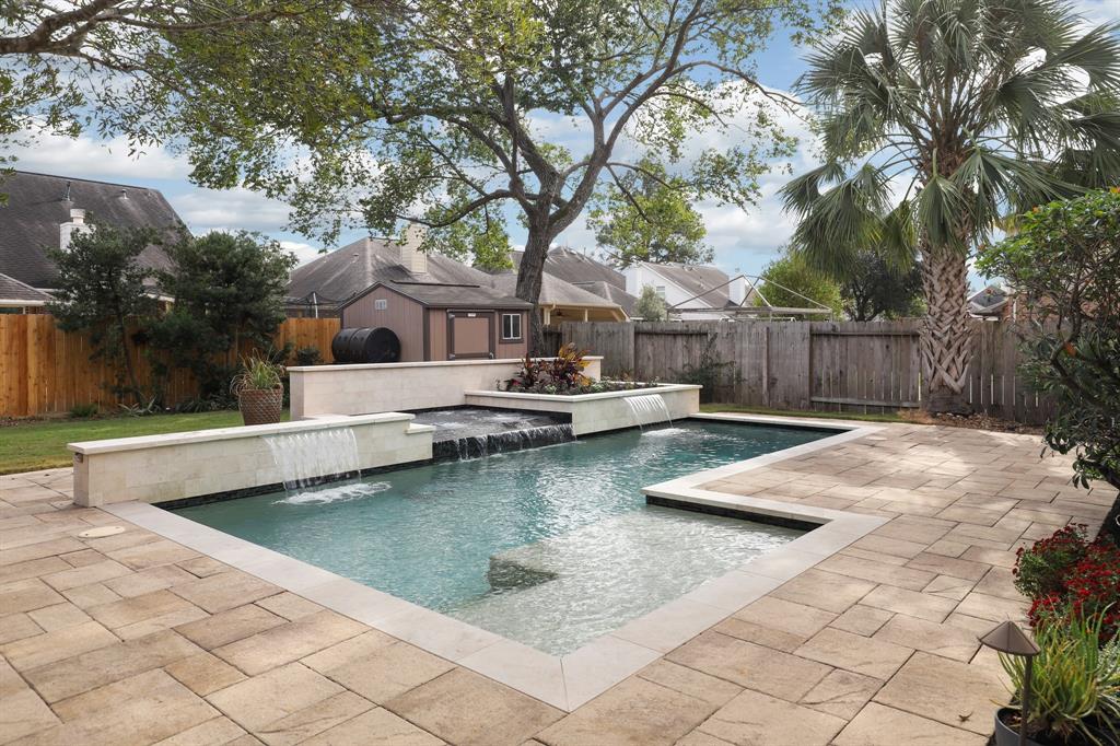 a view of house with swimming pool and a yard