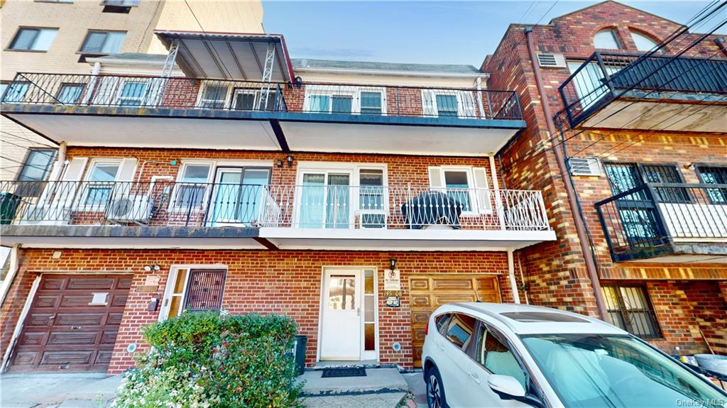 View of front of home featuring a balcony and a garage