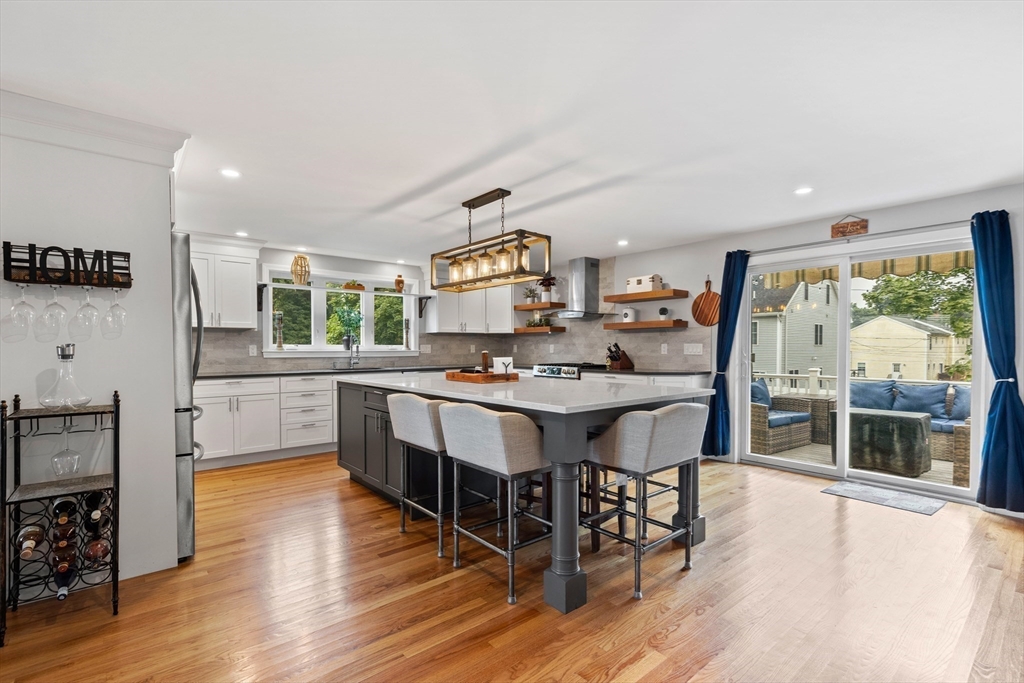 a kitchen with stainless steel appliances granite countertop a stove and a wooden floors