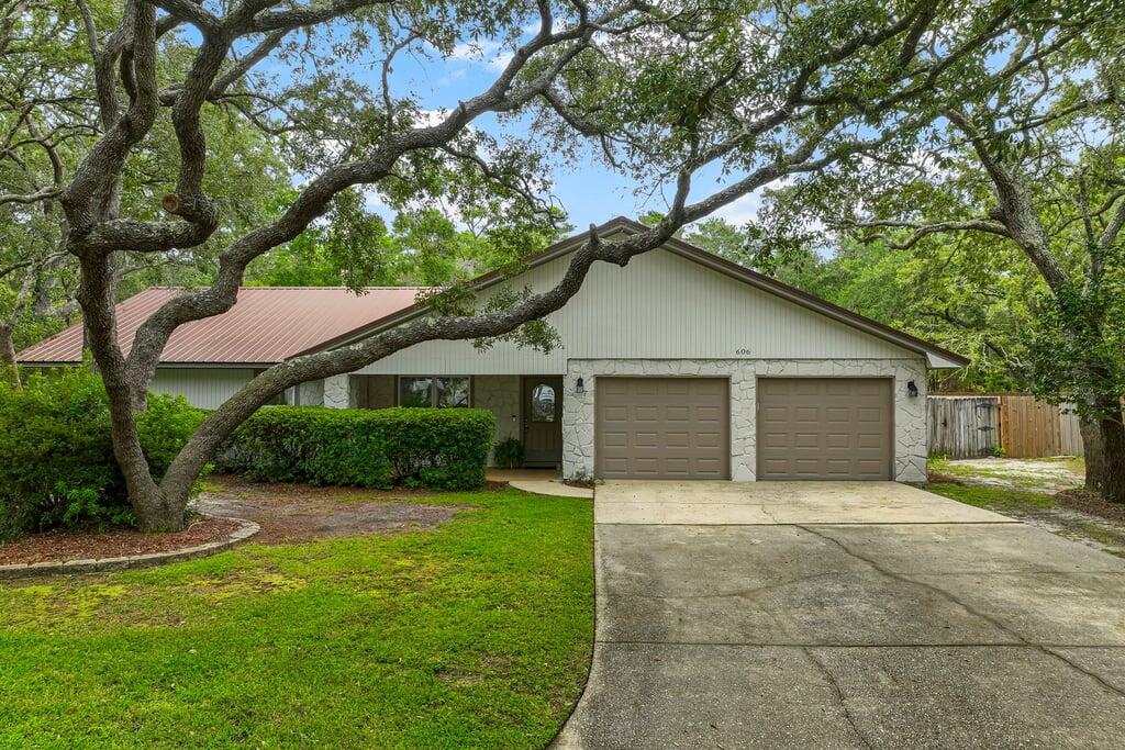 a view of a house with a yard and large tree