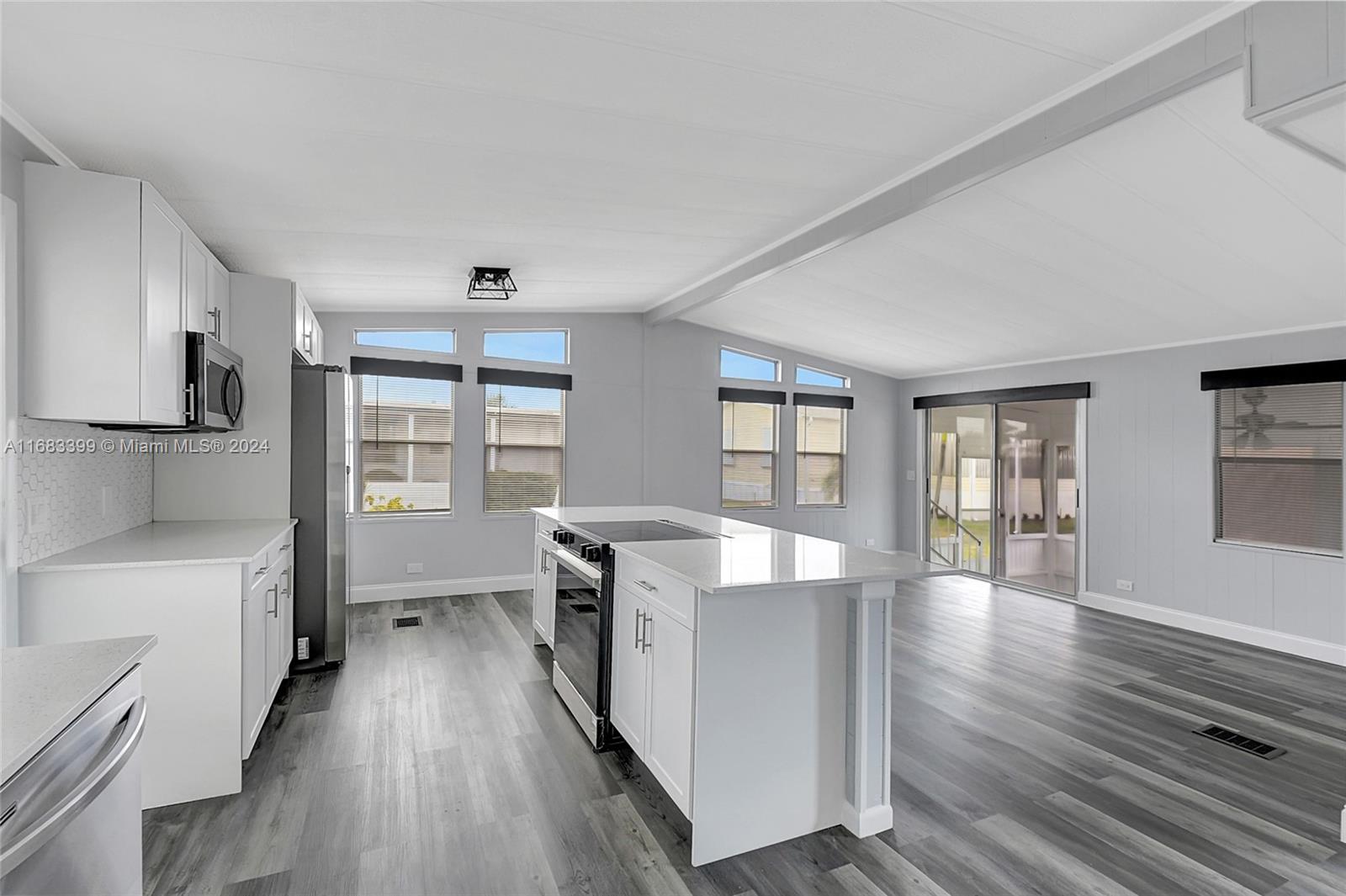 a view of a kitchen with fridge and wooden floor