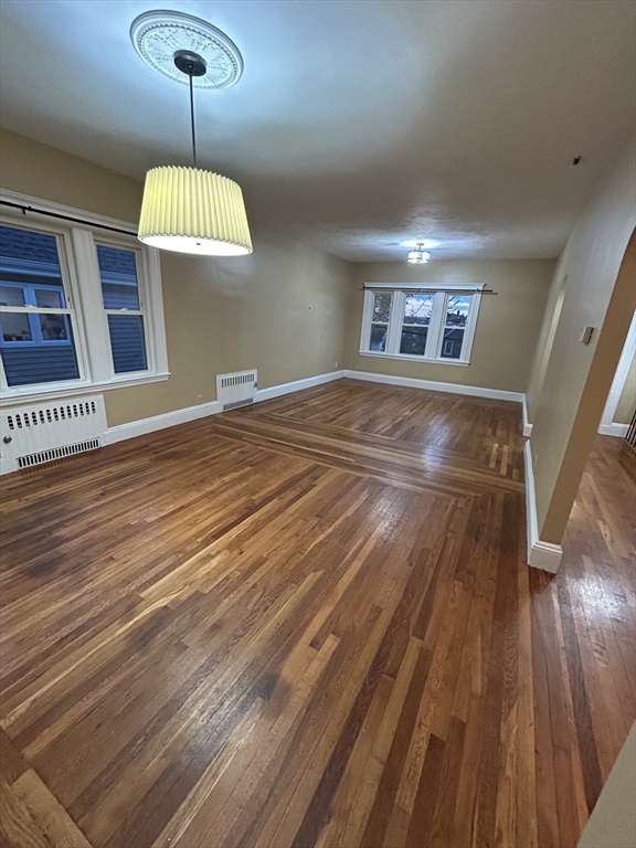 a view of an empty room with wooden floor