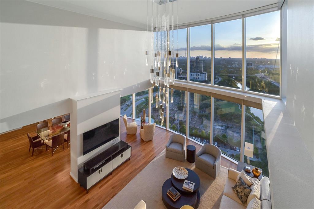 a living room with furniture a fireplace and a floor to ceiling window