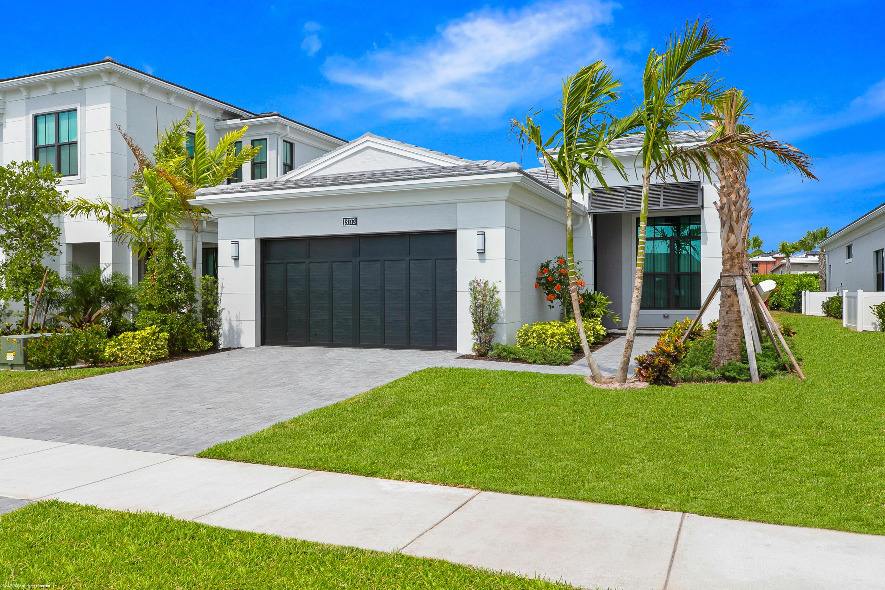 a front view of a house with a yard and potted plants