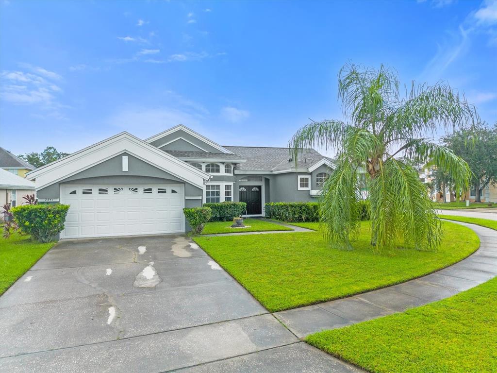 a view of a big house with a big yard and palm trees