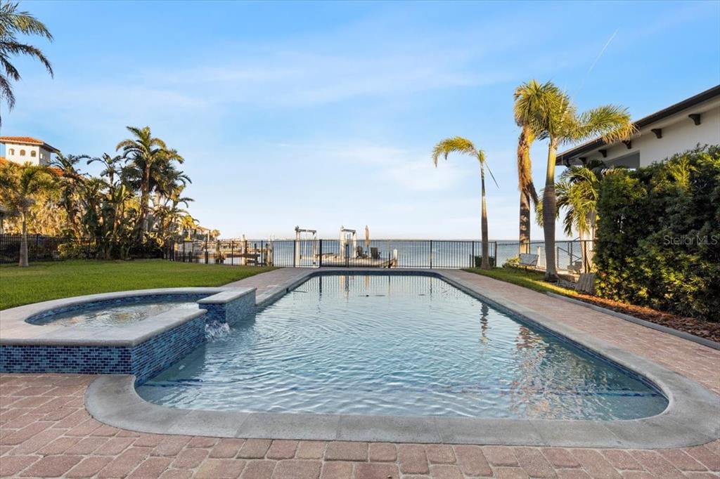 a view of a swimming pool with a yard and sitting space