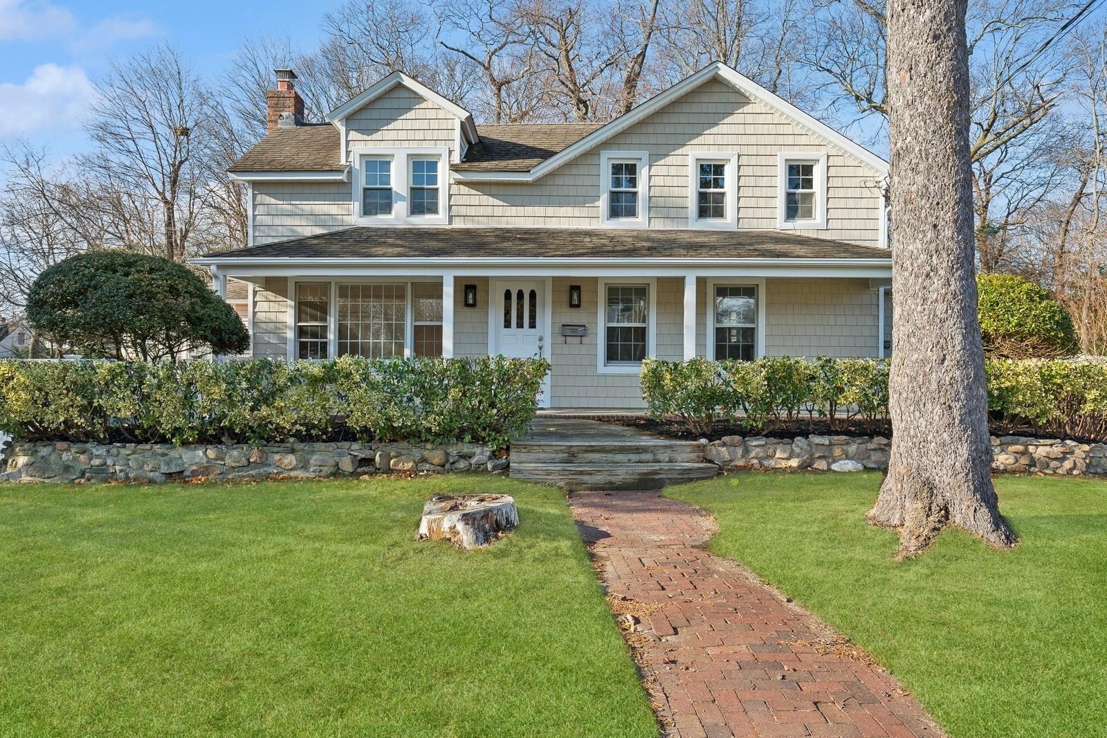 View of front of home with a front yard and covered porch