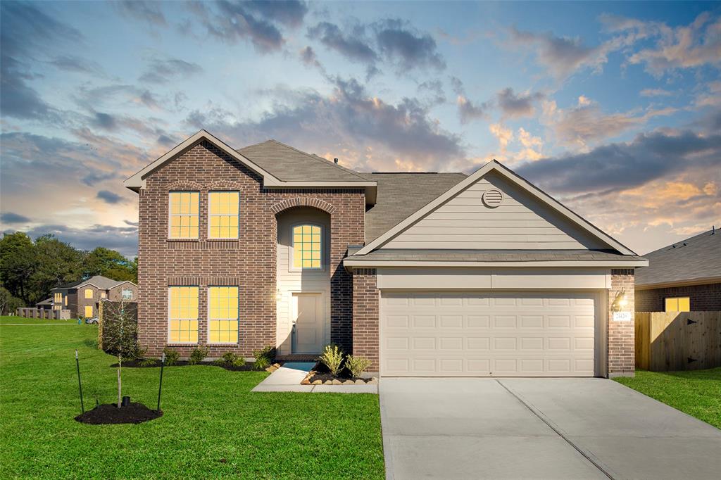 a front view of a house with a yard and garage