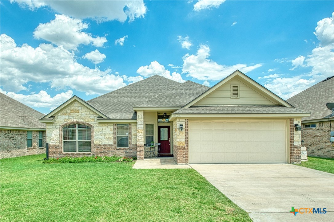 a front view of a house with a garden and yard