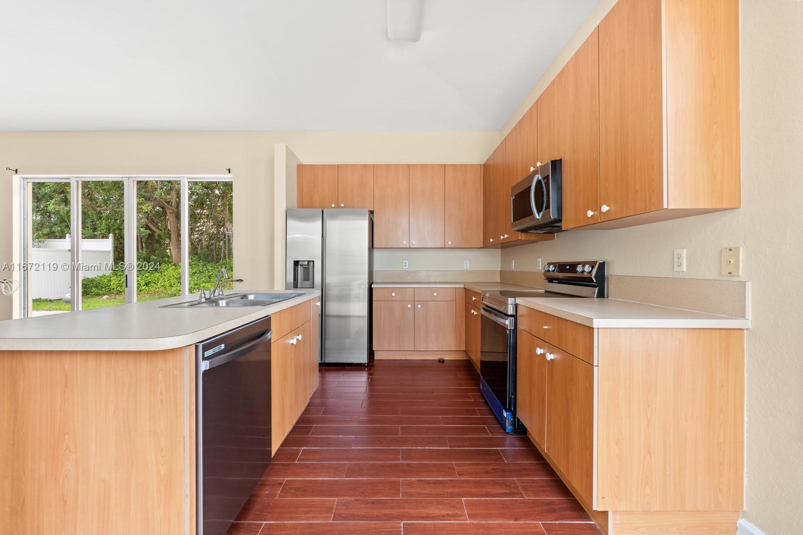 a kitchen with stainless steel appliances granite countertop a stove a sink and a refrigerator