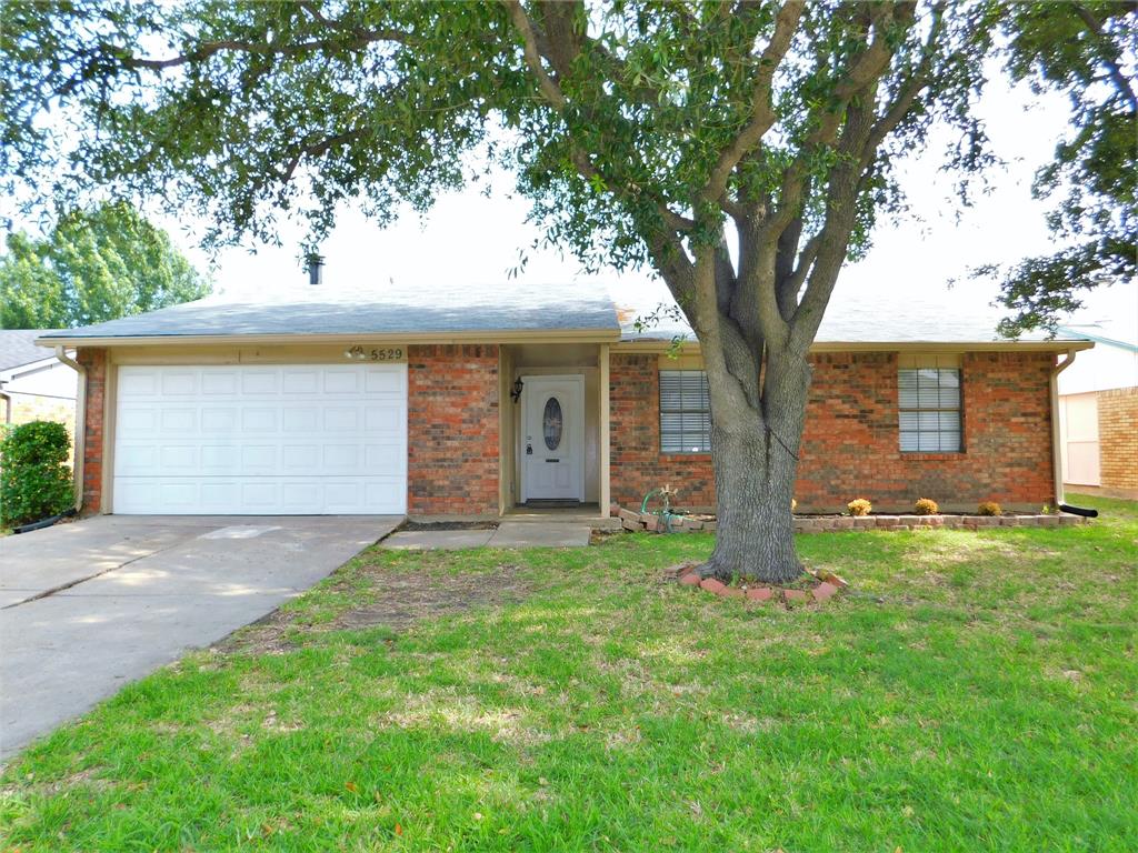 a house is sitting in middle od the grass