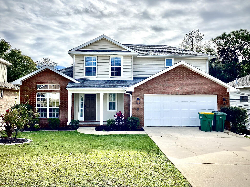 a front view of a house with a garden and plants