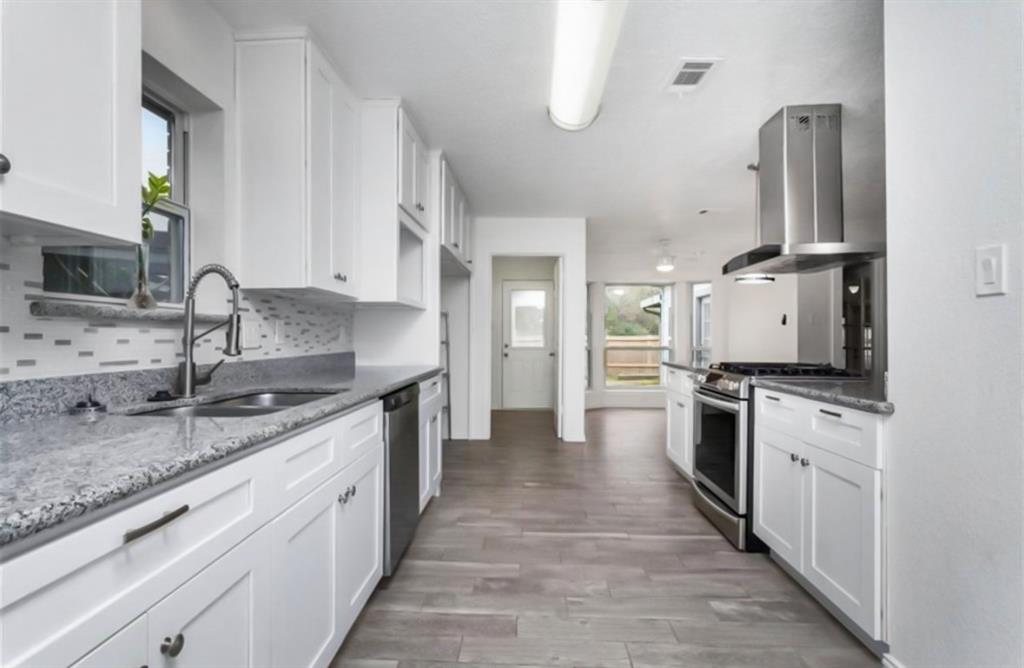 a kitchen with stainless steel appliances granite countertop a sink stove and refrigerator